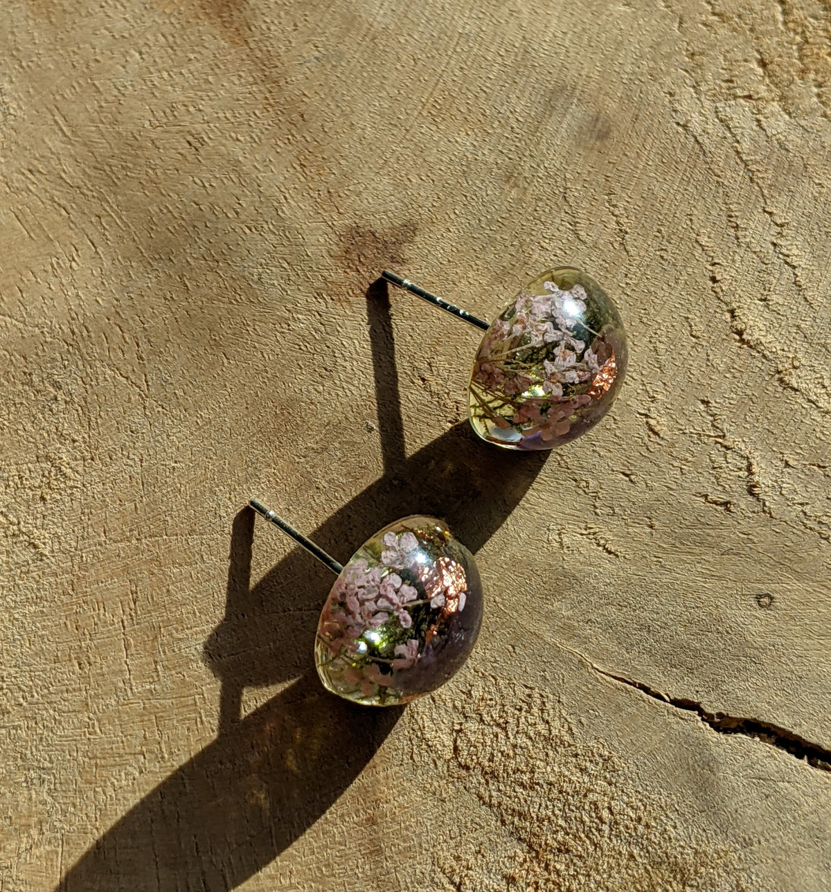 Close-up of amethyst preserved moss and real flower inside clear resin stud earrings, EL Creations