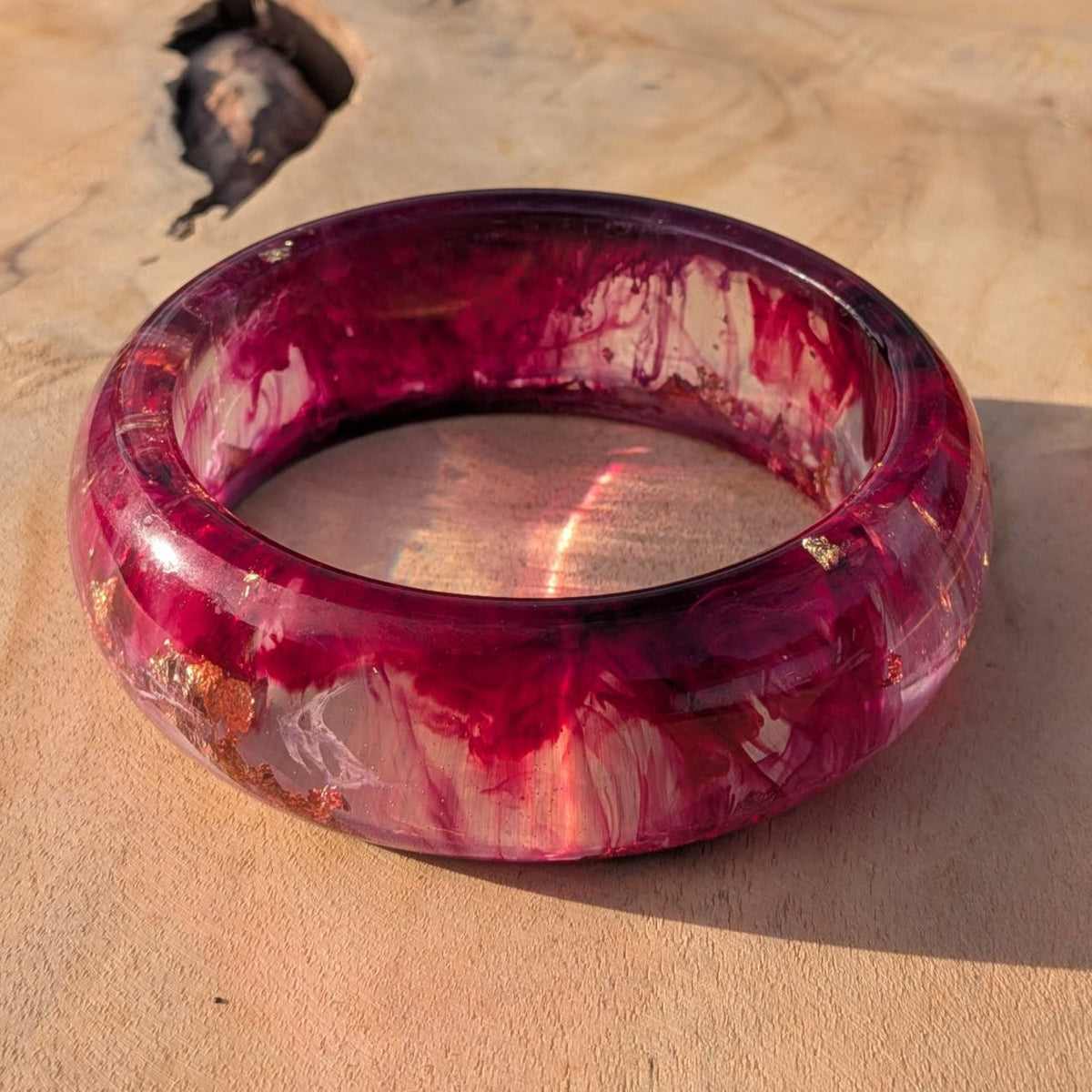 Deep burgundy resin bangle close-up on wrist showing rose gold shimmer and berry tones – EL-Creations