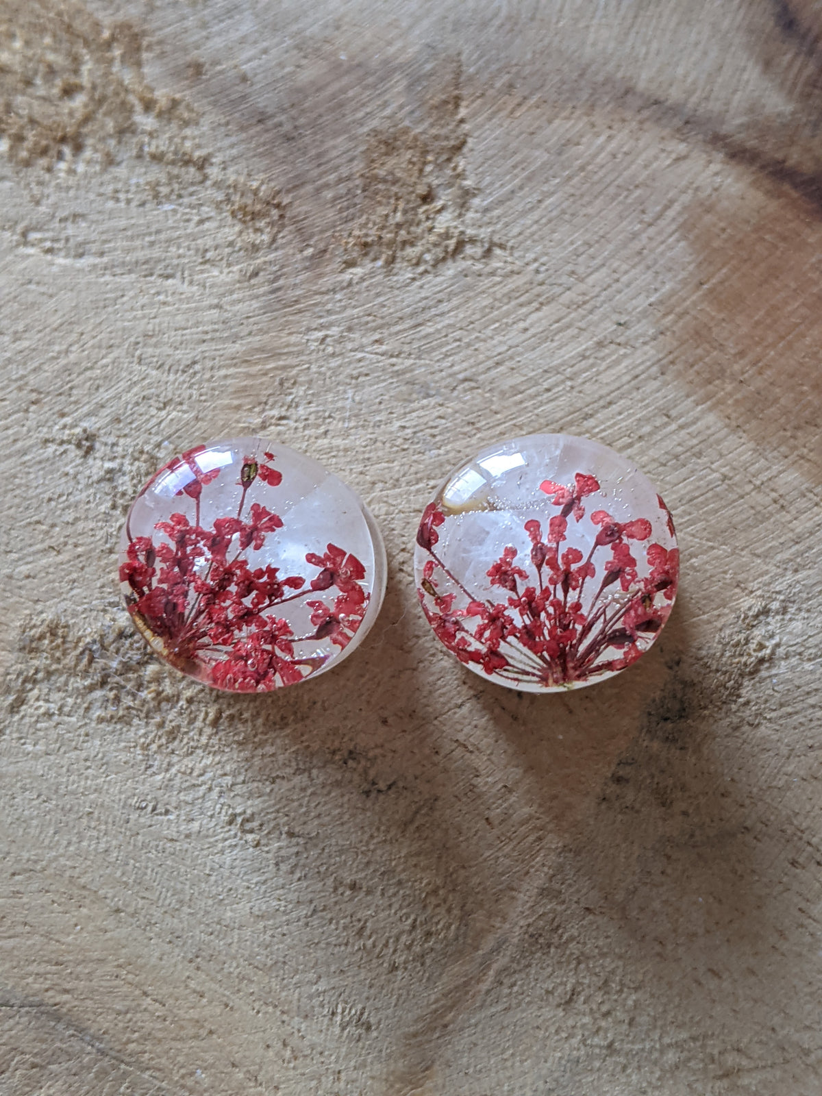 Close up of real rose quartz and red flower inside resin ear plugs EL-Creations