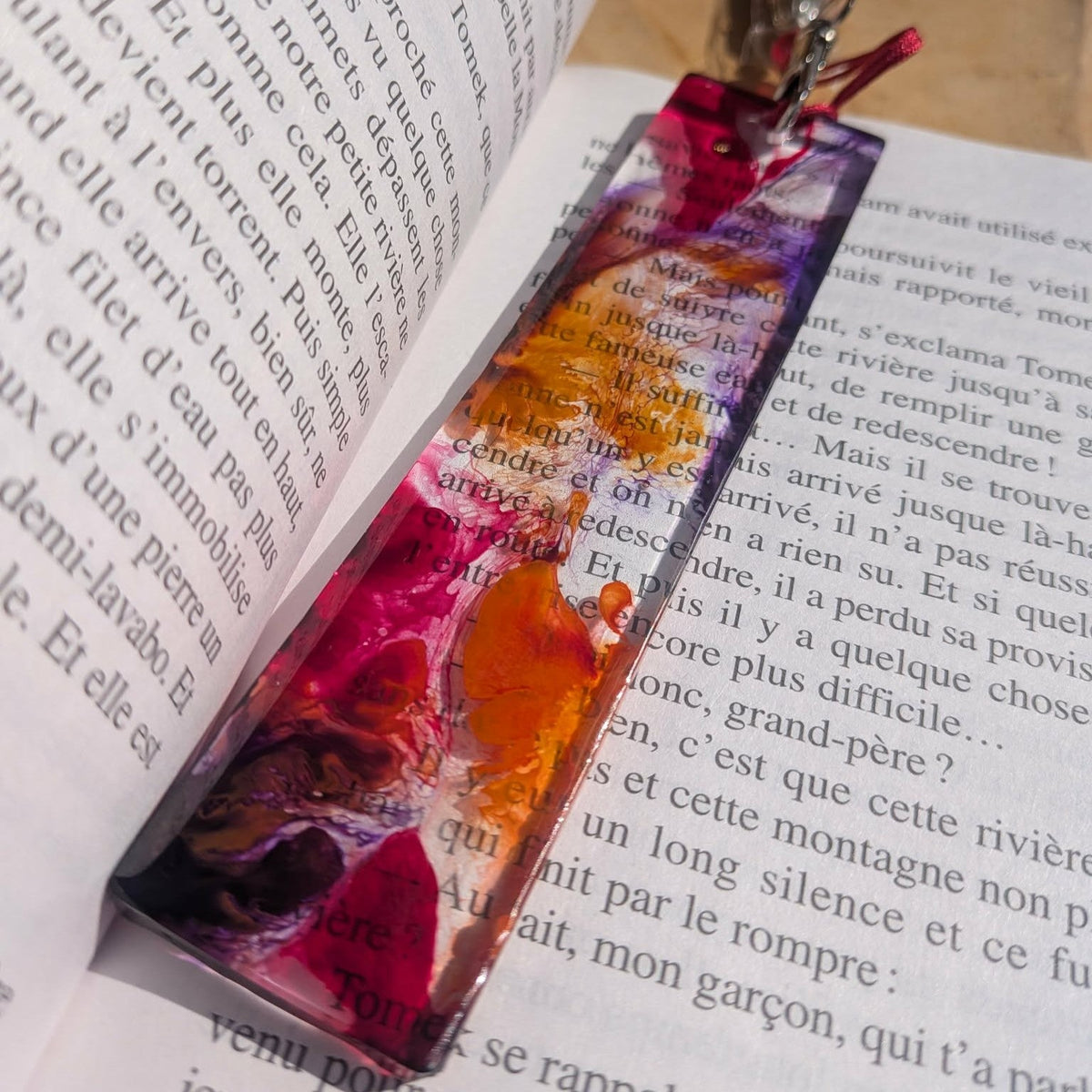 Full length wild bloom resin bookmark resting in book spine with red cord clasp – EL-Creations
