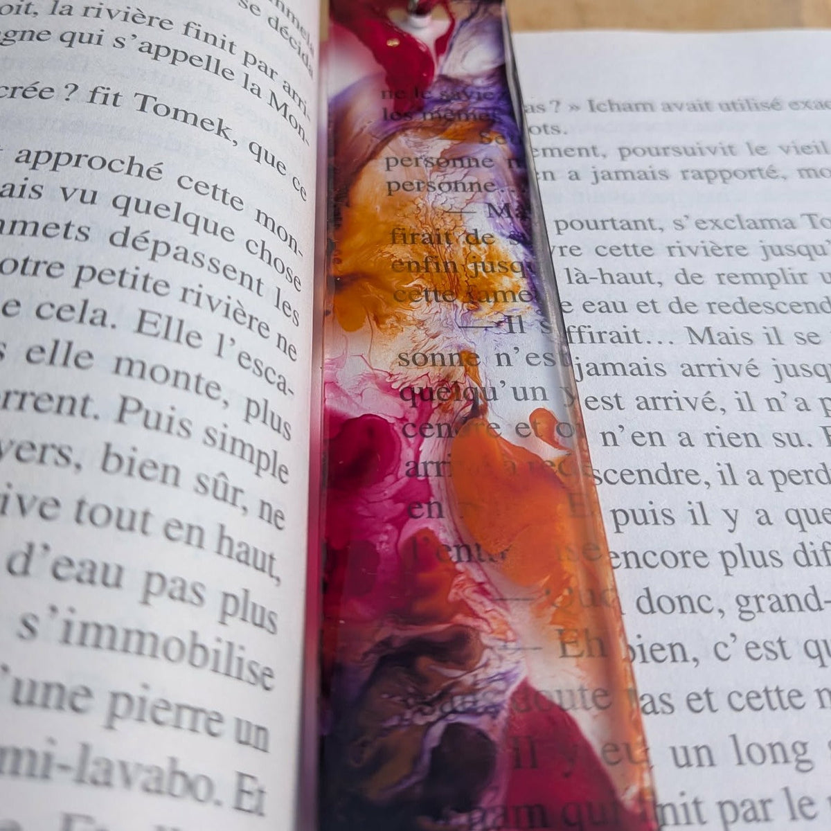 Wild bloom resin bookmark with red tassel keychain on open French book pages – EL-Creations