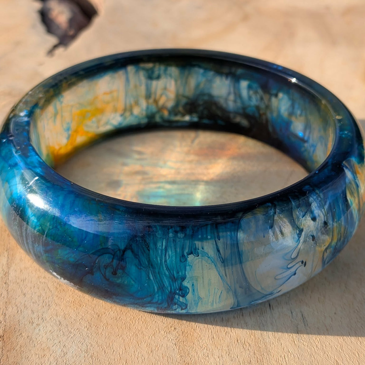 Deep ocean resin bangle inner diameter view showing blue teal swirls and gold streaks – EL-Creations