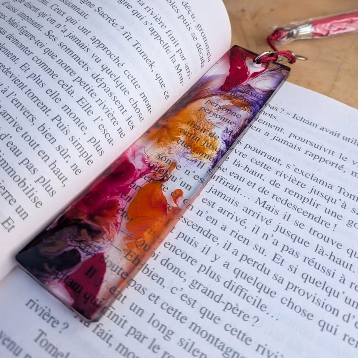 Close-up of raspberry orange and lavender alcohol ink swirl in epoxy resin bookmark – EL-Creations