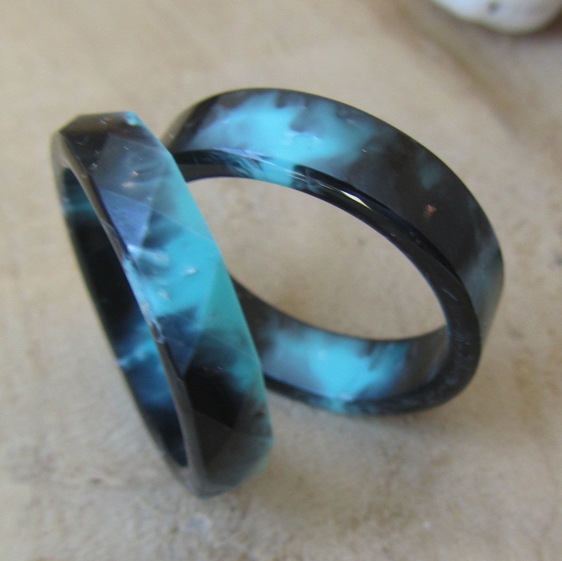 Black turquoise resin ring for men and women - top view on wood