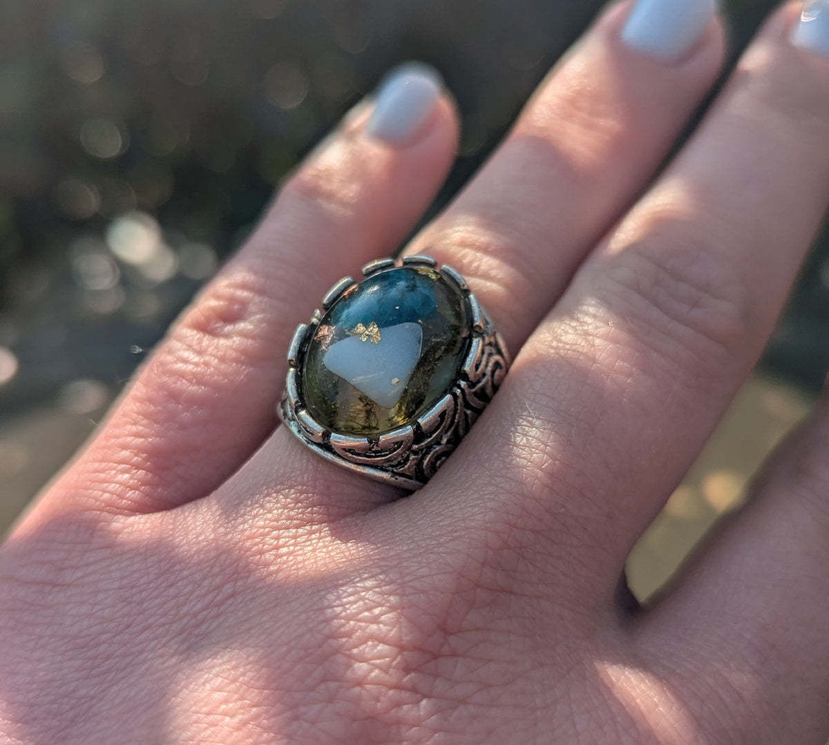 Close-up of blue tourmaline and white stone in clear resin ring — botanical jewelry EL-Creations