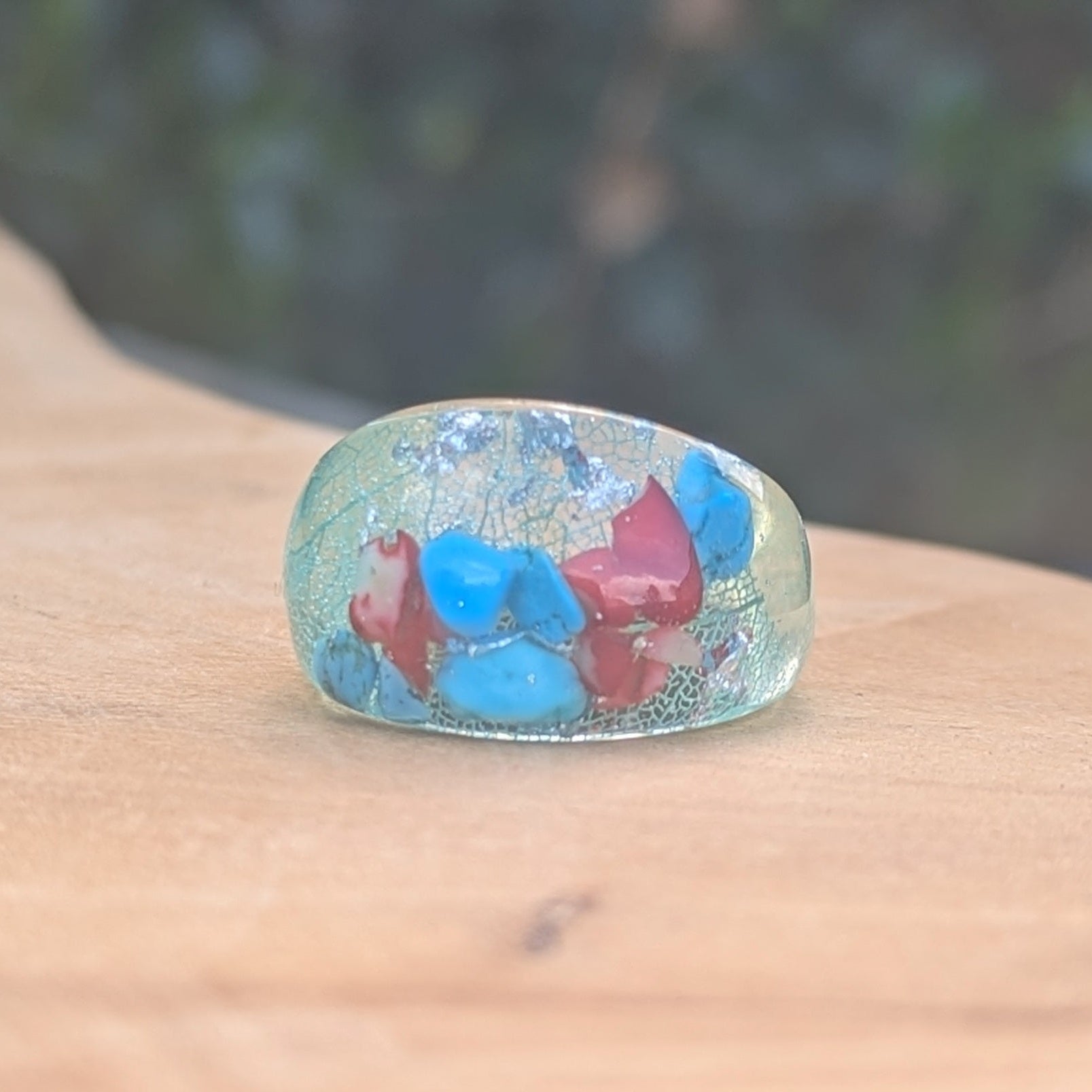 Ring with colorful stones on a wooden surface