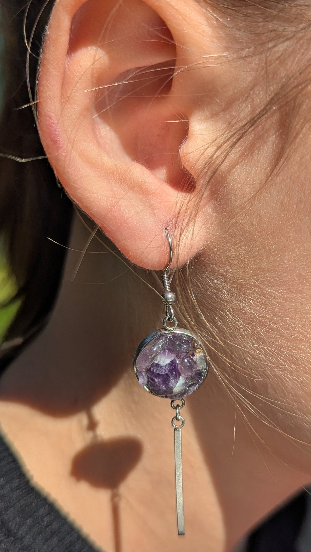 Amethyst resin bar earrings worn on ear, purple gemstone statement jewelry EL Creations Belgium