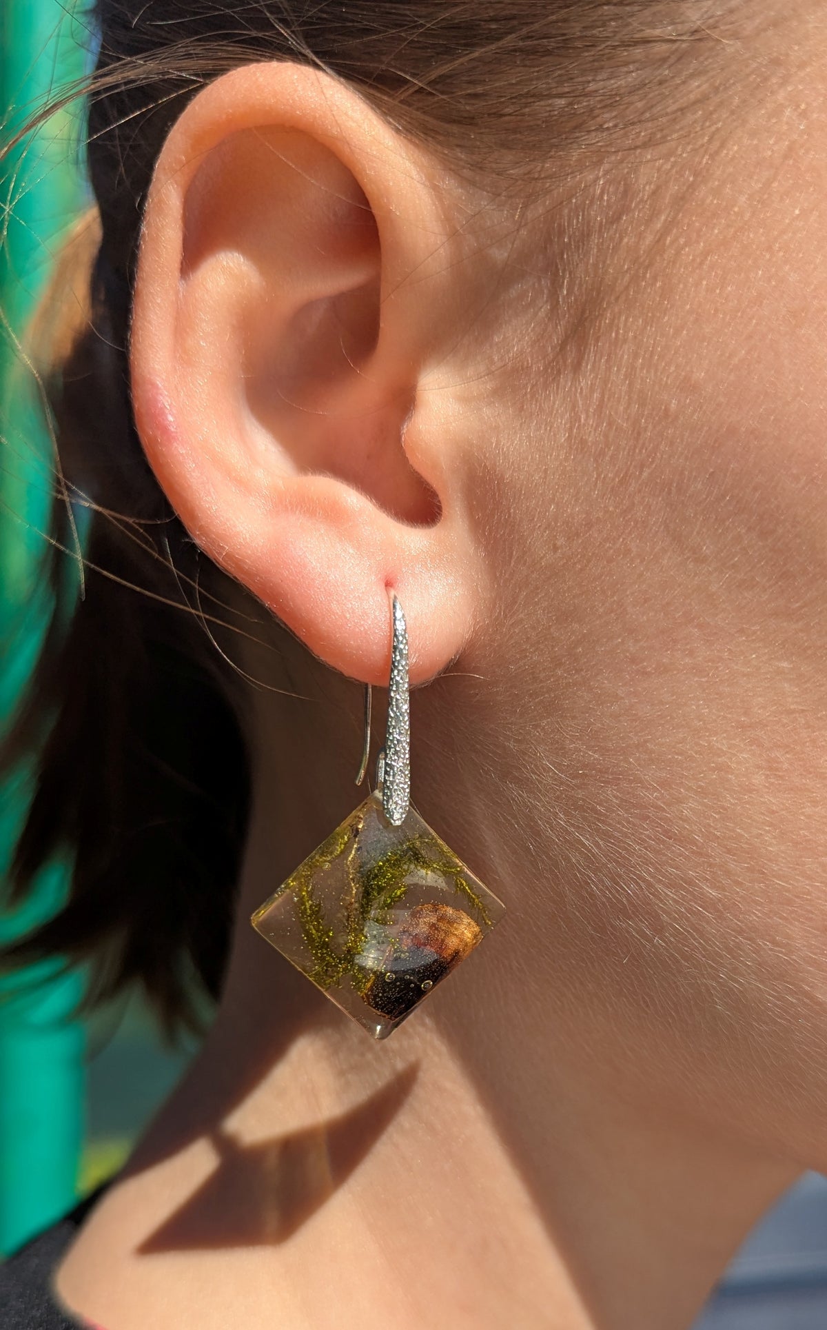 Close-up of real forest moss and mushroom inside clear resin square earrings, EL Creations