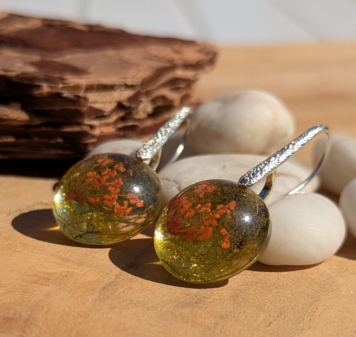 Pressed flower and forest moss resin earrings 18mm on wooden surface, EL Creations