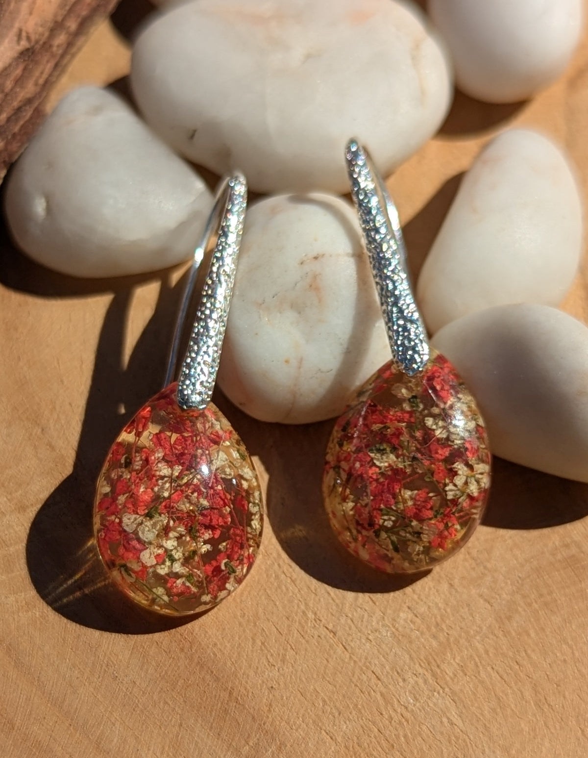 Real red white flower gold flake resin teardrop earrings 13x18mm on stone surface, EL Creations
