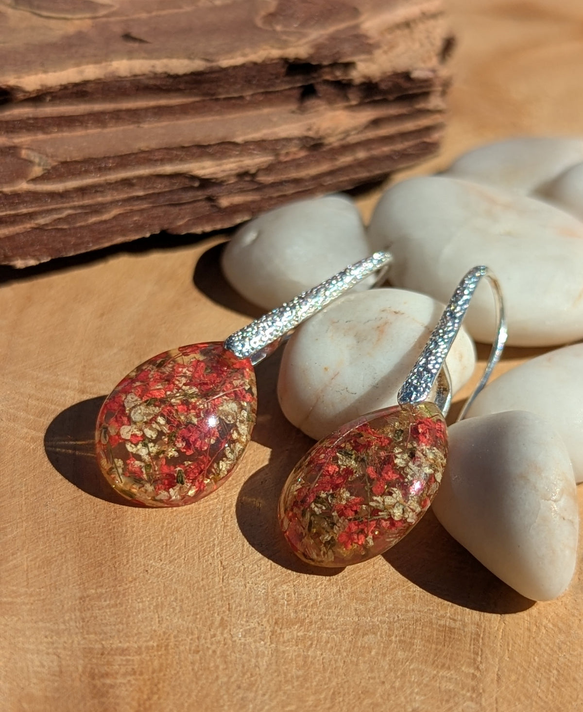 Real red white flower gold flake resin teardrop earrings 13x18mm on stone surface, EL Creations
