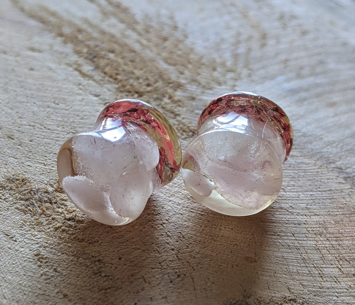 Close up of real rose quartz and red flower inside resin ear plugs EL-Creations