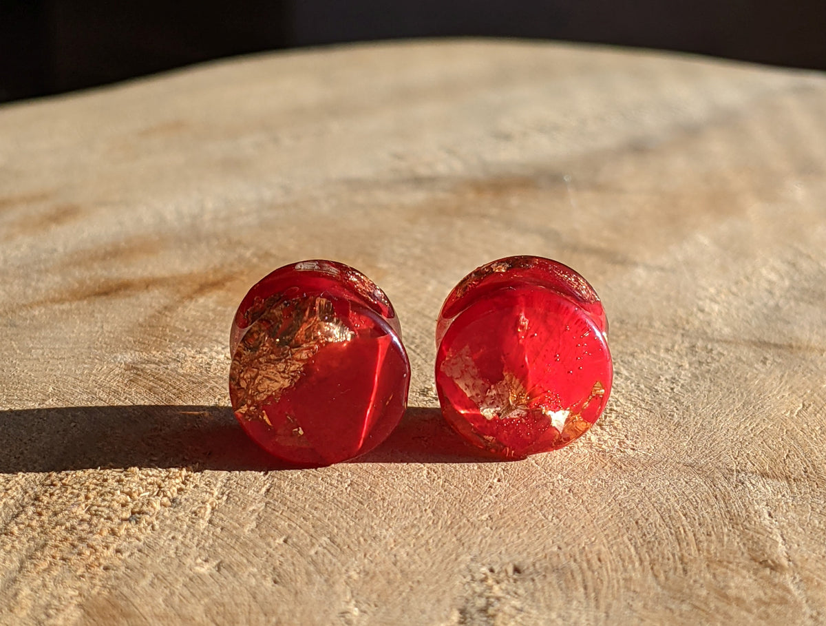 Close up of real red tulip petals and copper flakes inside resin ear plugs EL-Creations