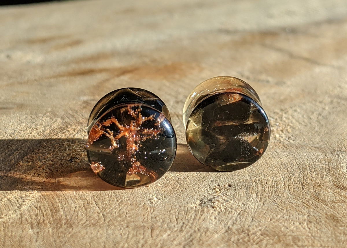 Close up of black obsidian stone and green moss inside resin plugs EL-Creations