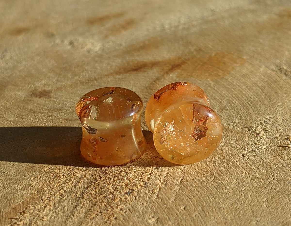Close up view of orange carnelian stone inside resin ear plugs EL-Creations