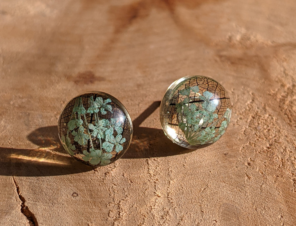 Real turquoise flower and skeleton leaf resin studs 12mm on beige surface, EL Creations