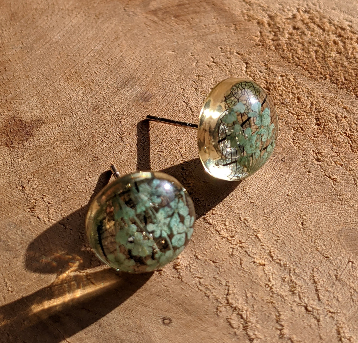 Handmade turquoise flower skeleton leaf resin stud earrings worn on ear, nature jewelry EL Creations Belgium