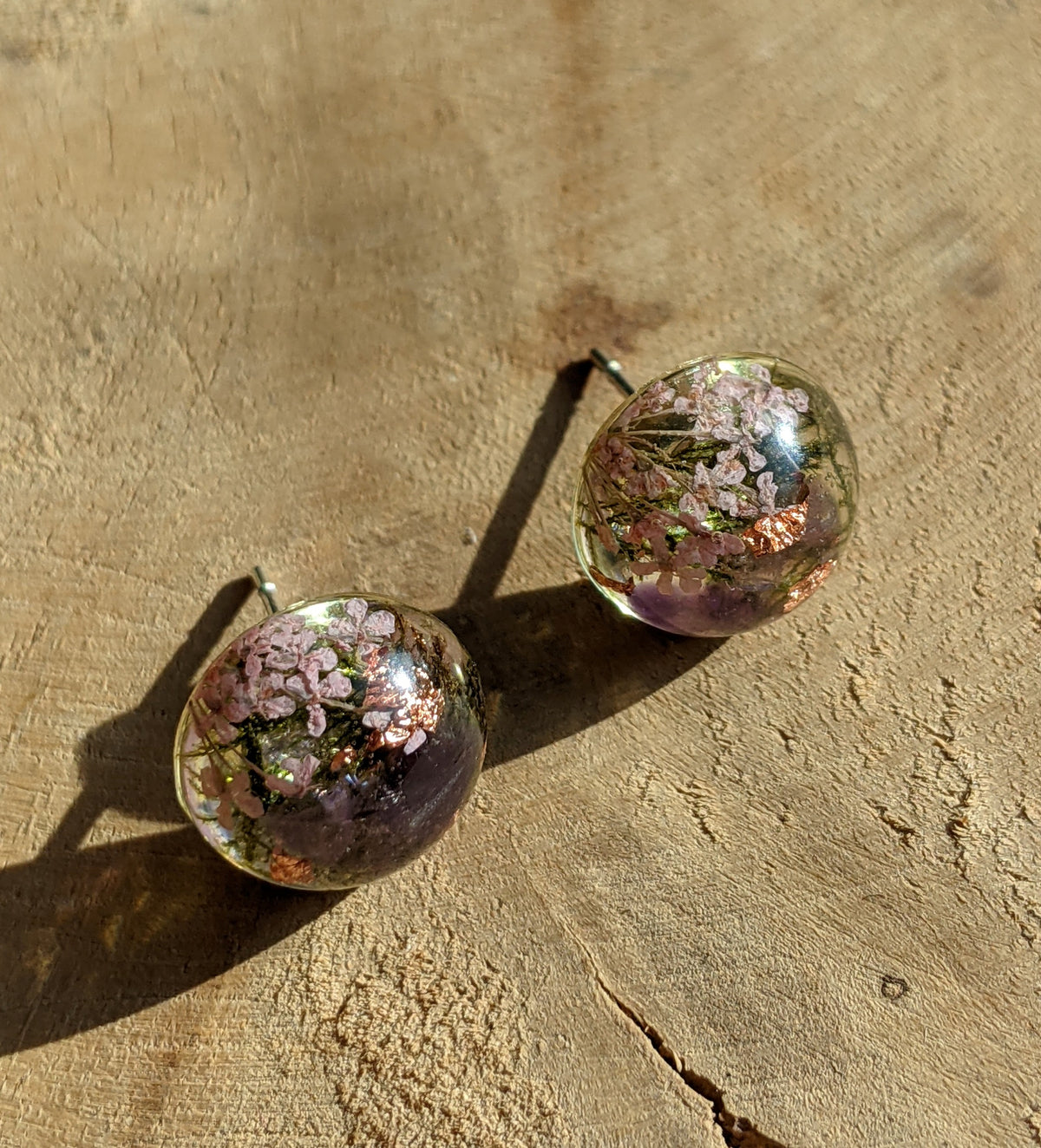 Handmade amethyst and moss resin stud earrings worn on ear, botanical gemstone jewelry Belgium