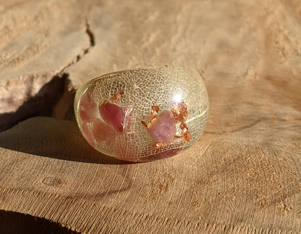 Decorative glass bowl with pink interior on a textured surface