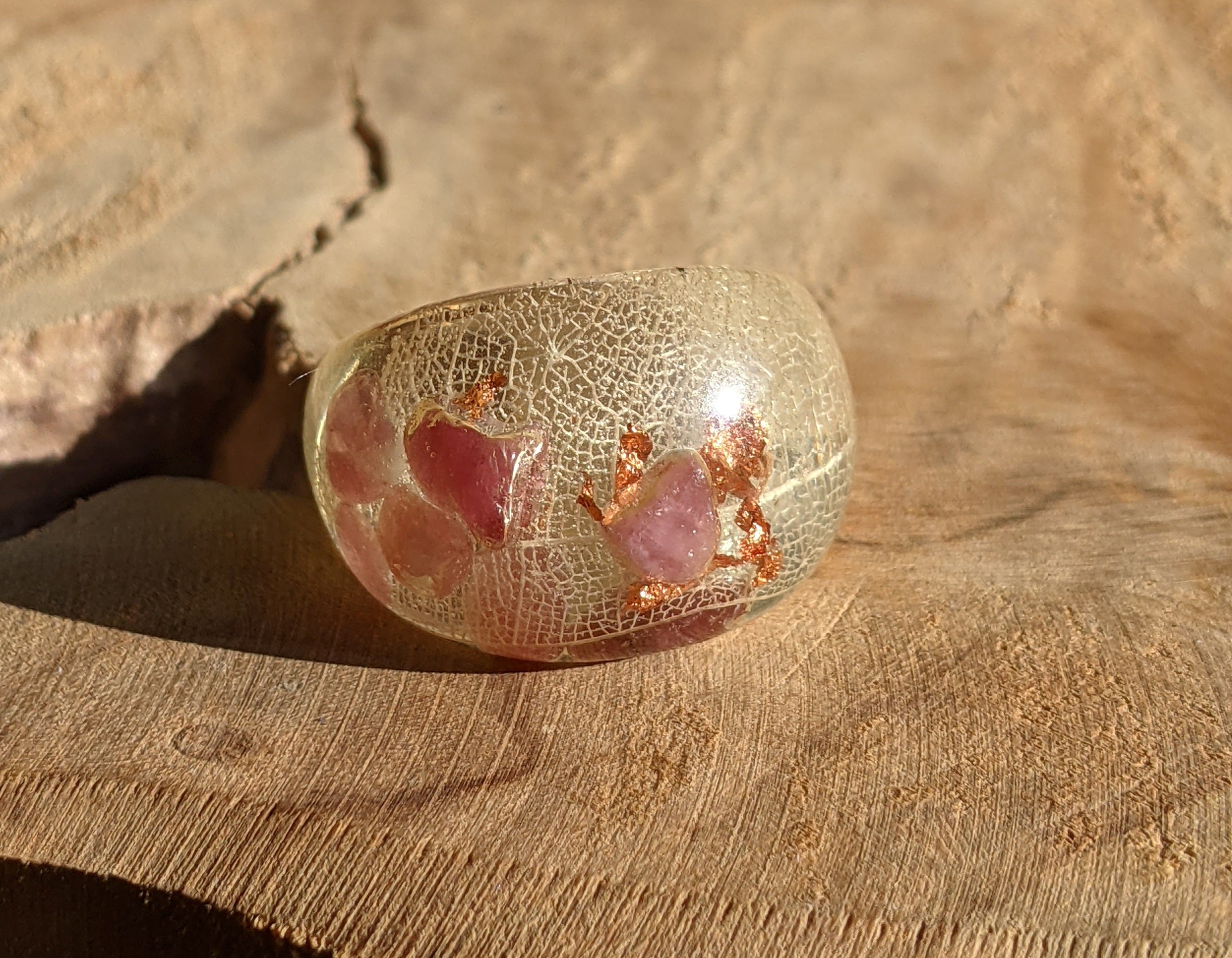 Decorative glass bowl with pink interior on a textured surface