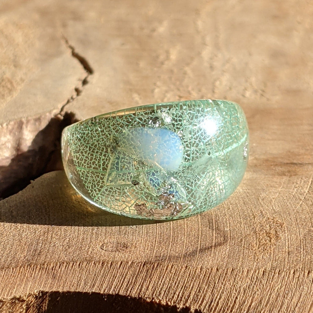 Aquamarine leaf resin ring - top view on wood background