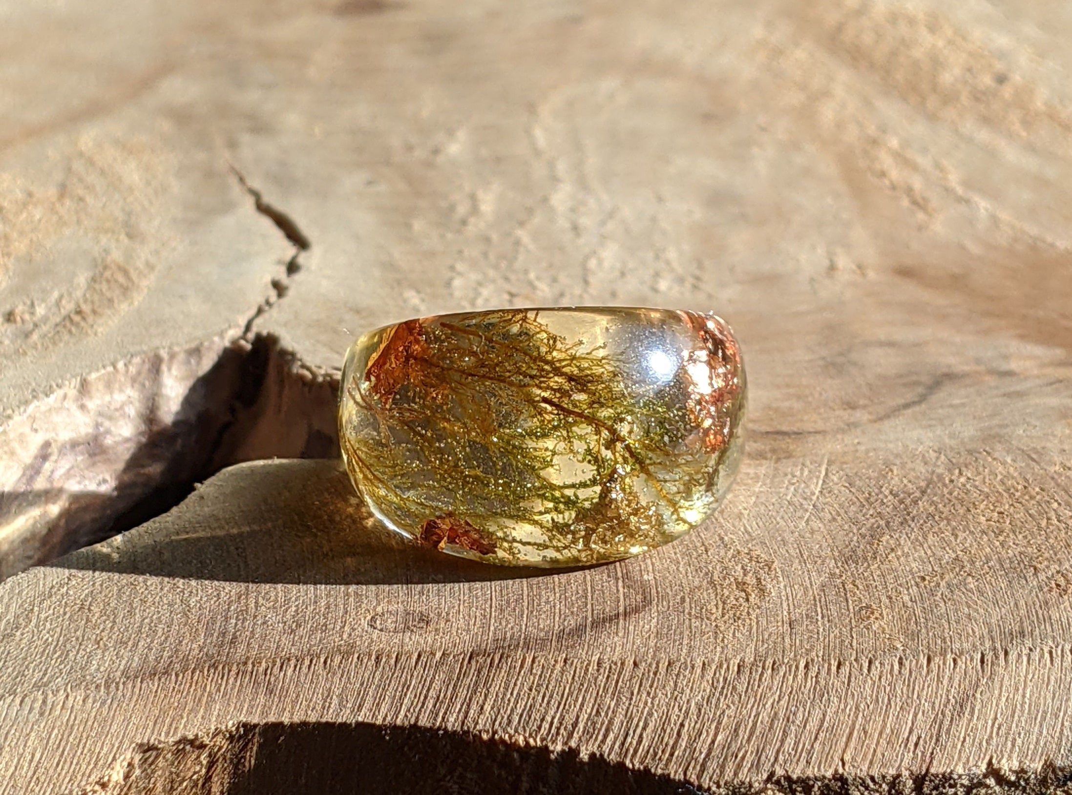 Translucent gemstone with natural patterns on a wooden surface