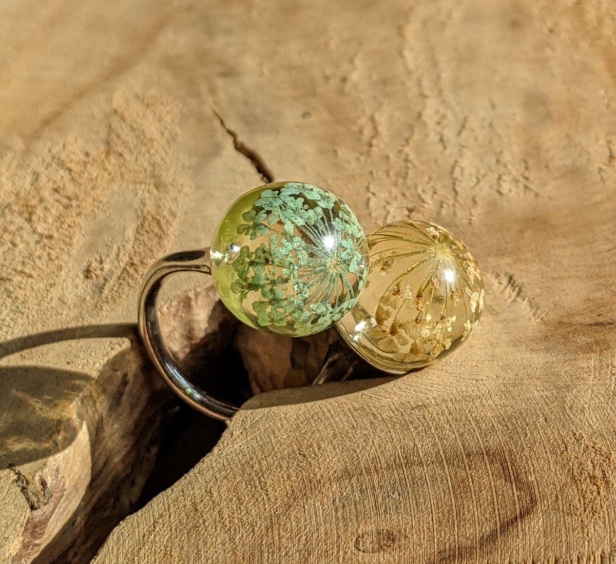 Close-up of dried flowers inside clear resin sphere ring, EL-Creations