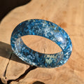Blue and clear resin ring on a wooden surface