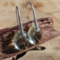 Pair of earrings with clear stones on a wooden surface