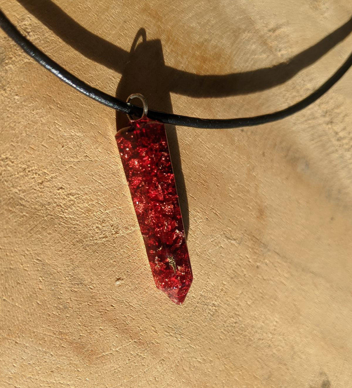 Close up view of gold copper silver  flakes inside red crystal point resin necklace pendant EL-Creations