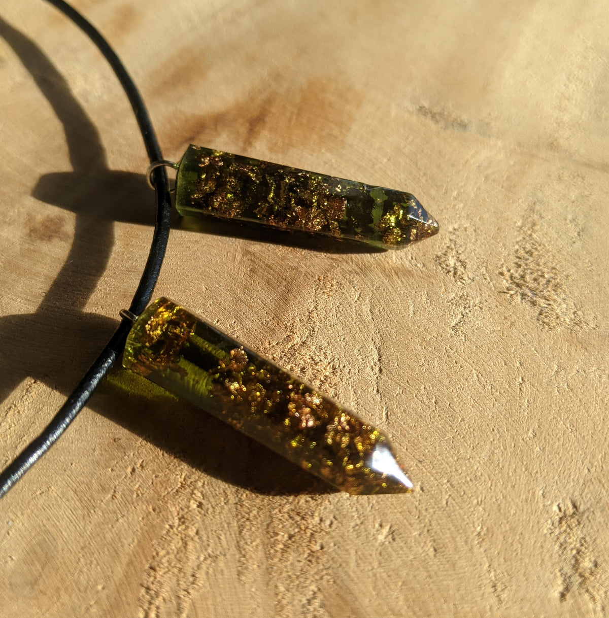 Close up view of copper flakes inside green resin crystal point pendant EL-Creations
