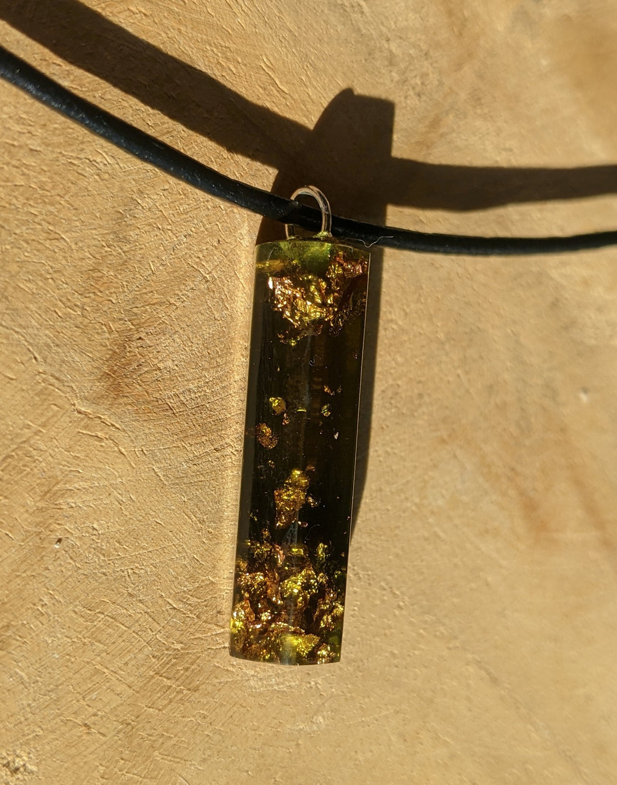 Close up view of copper flakes inside green crystal point resin necklace EL-Creations