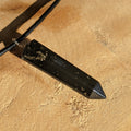 Black crystal pendant on a beige surface