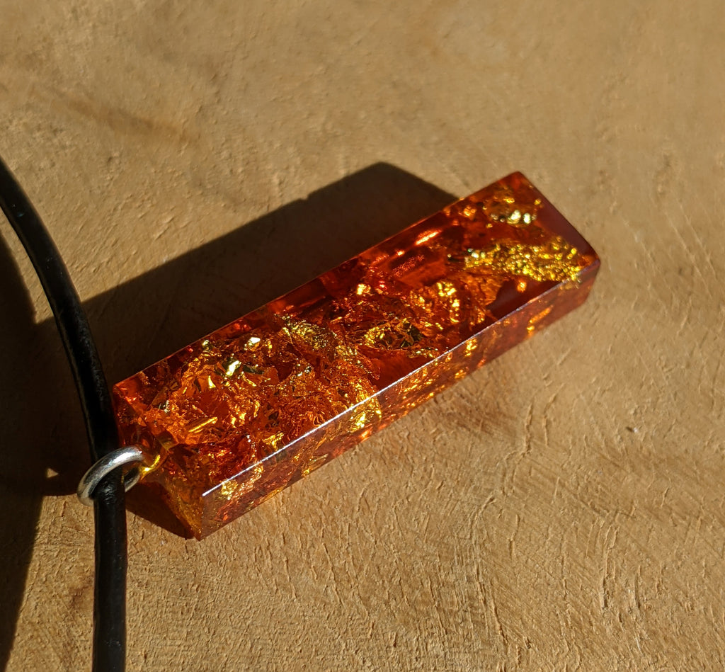 Collier rectangulaire en résine ambrée avec paillettes d'or et de cuivre et cordon en cuir ajustable