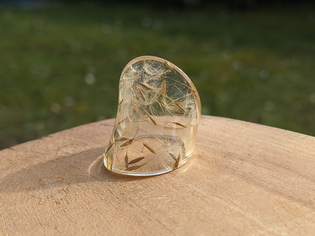 Clear crystal on a wooden surface with a blurred natural background