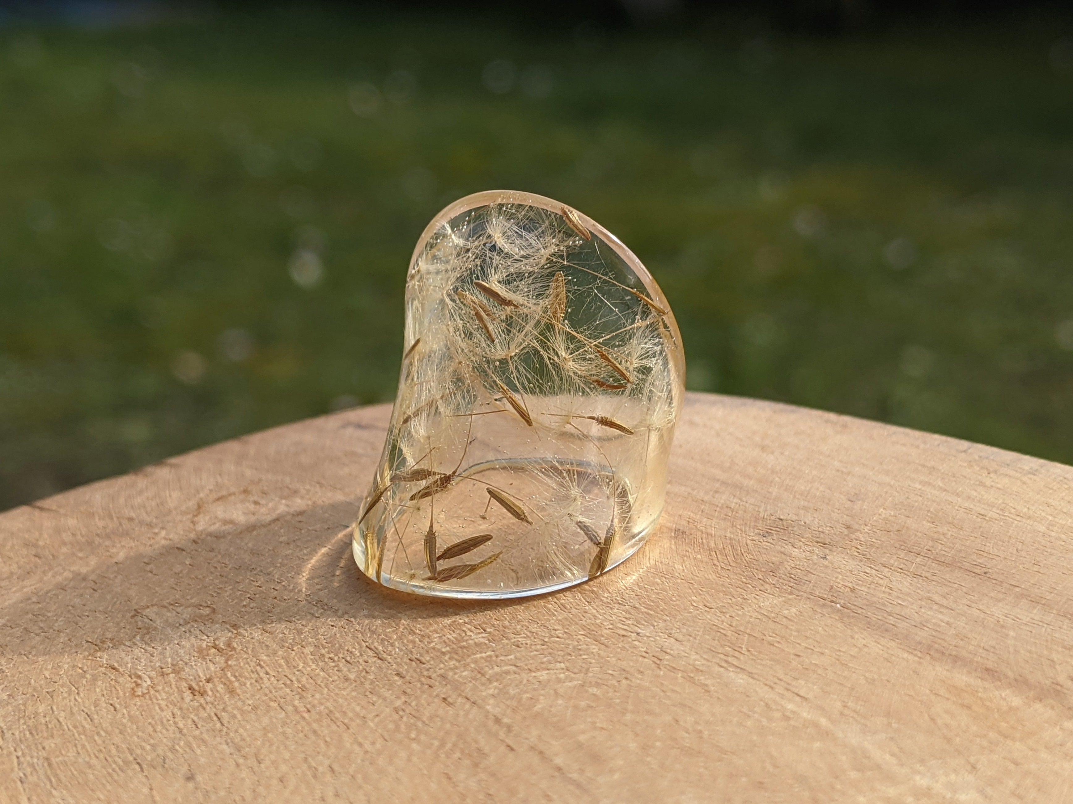 Clear crystal on a wooden surface with a blurred natural background