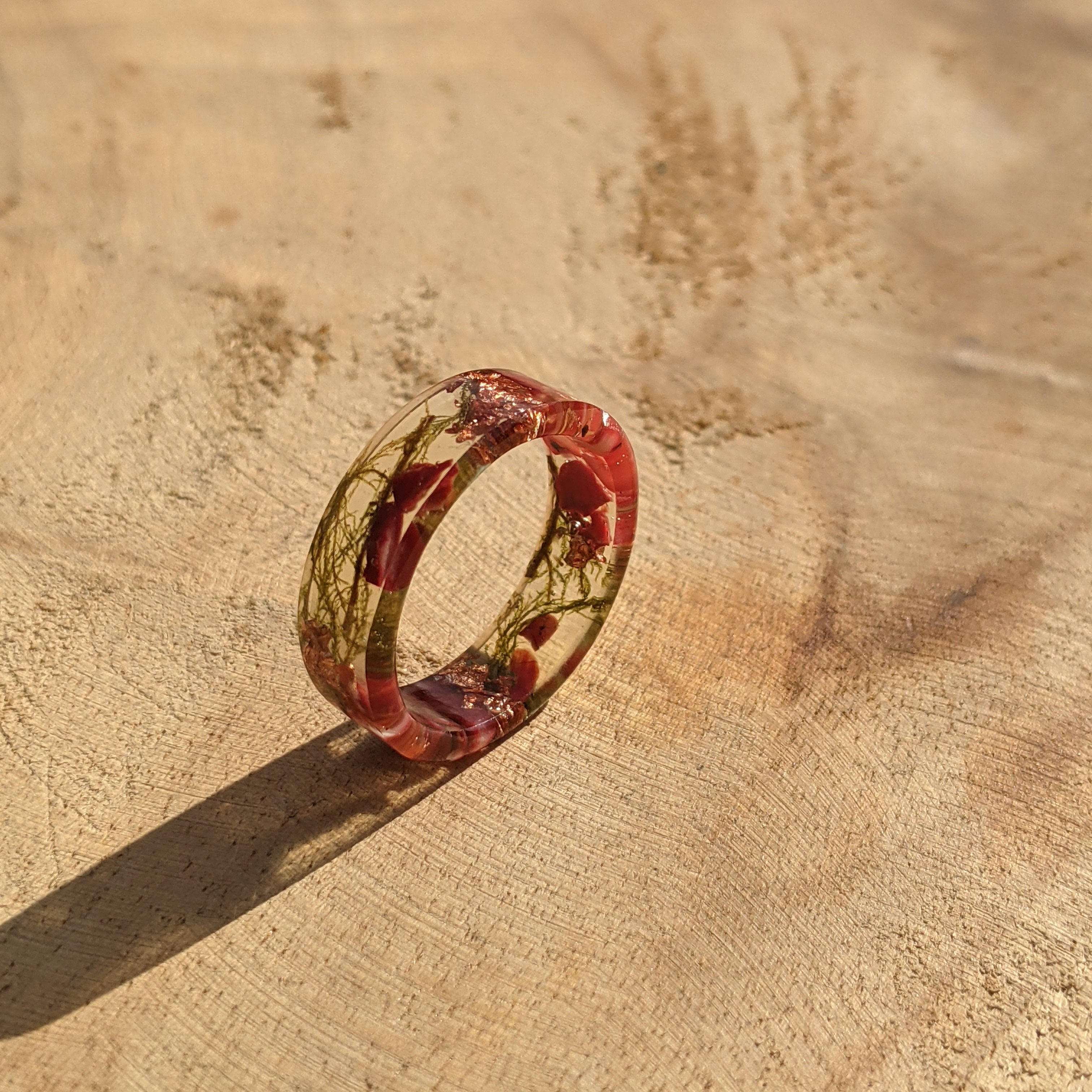 Ring with a red and clear design on a wooden surface