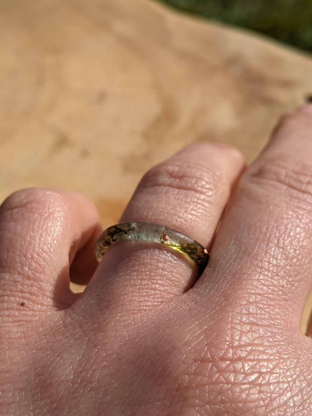 Close-up of a hand wearing a ring with a blurred background