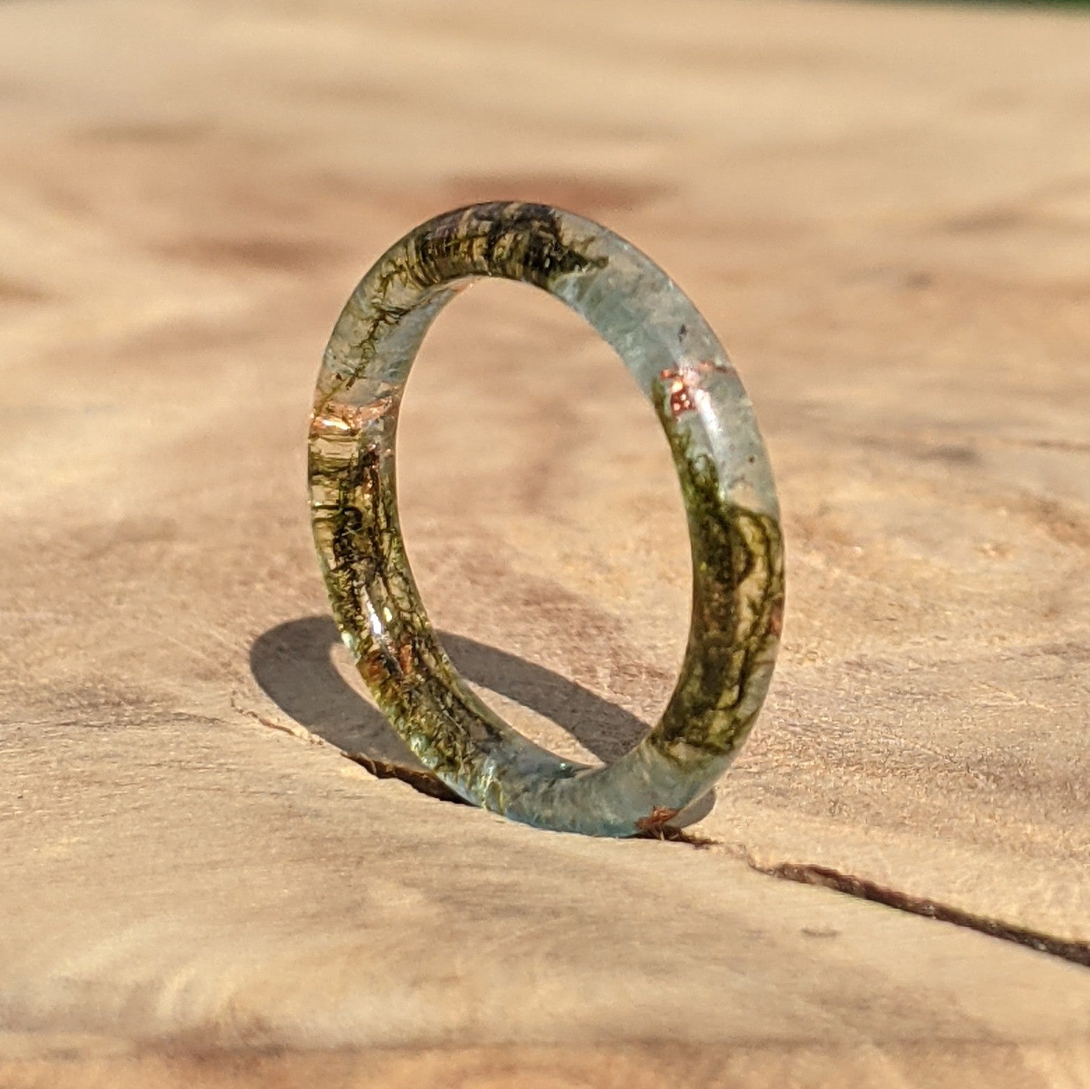 Translucent green ring on a wooden surface