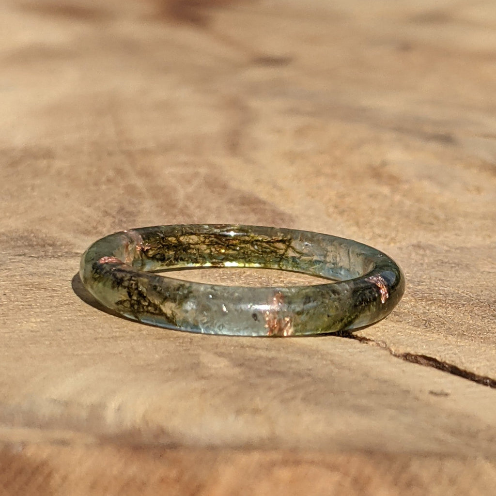 Greenish-brown thin ring on a wooden surface