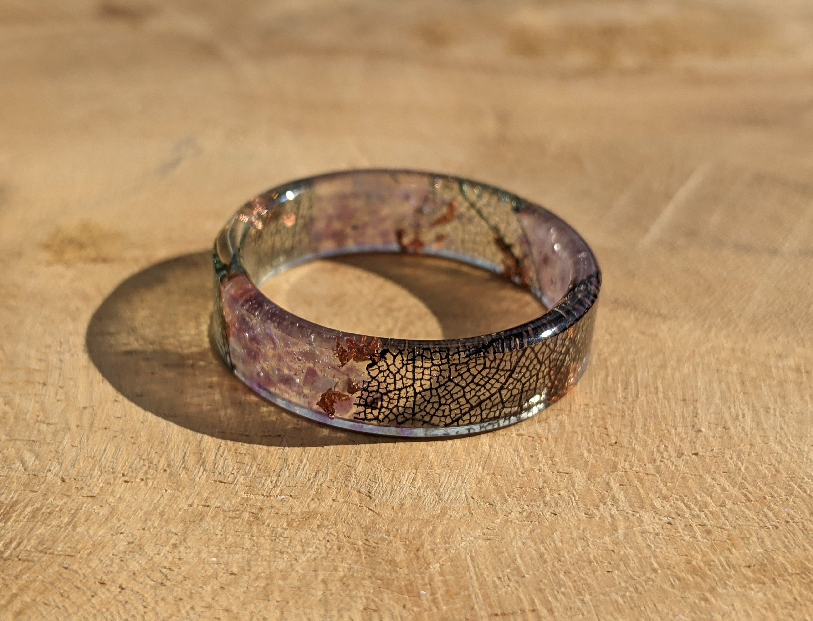 Resin ring with a cracked glass design on a wooden surface