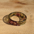 Round resin coaster with leaf pattern on a wooden surface