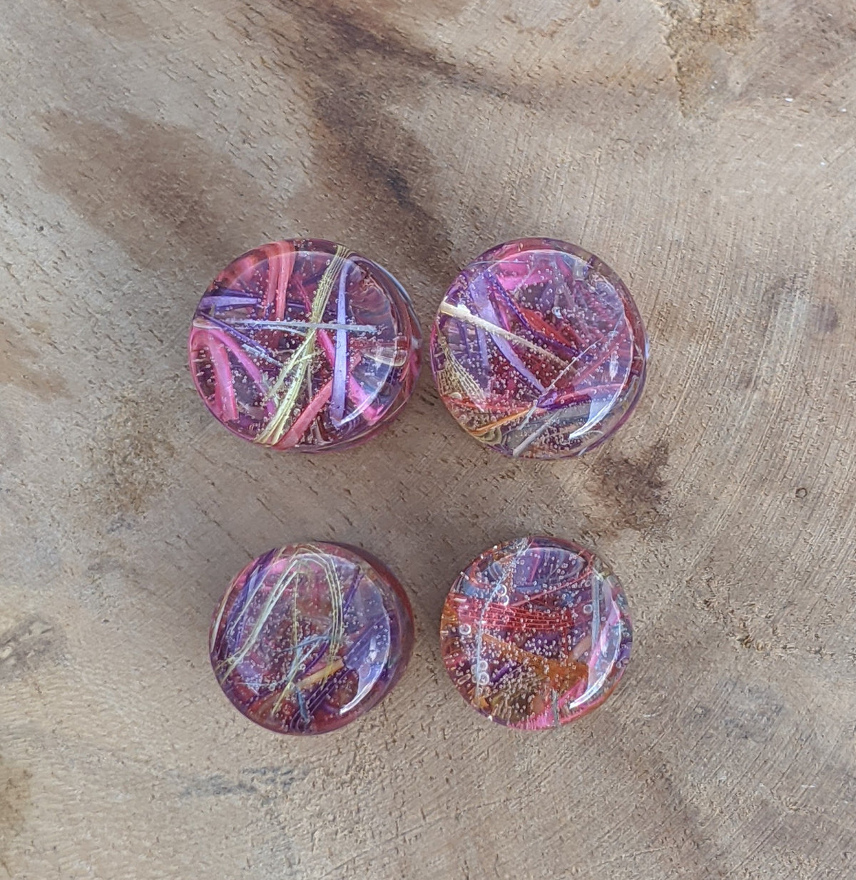 Artisan resin ear plugs featuring vibrant rainbow feathers EL-Creations