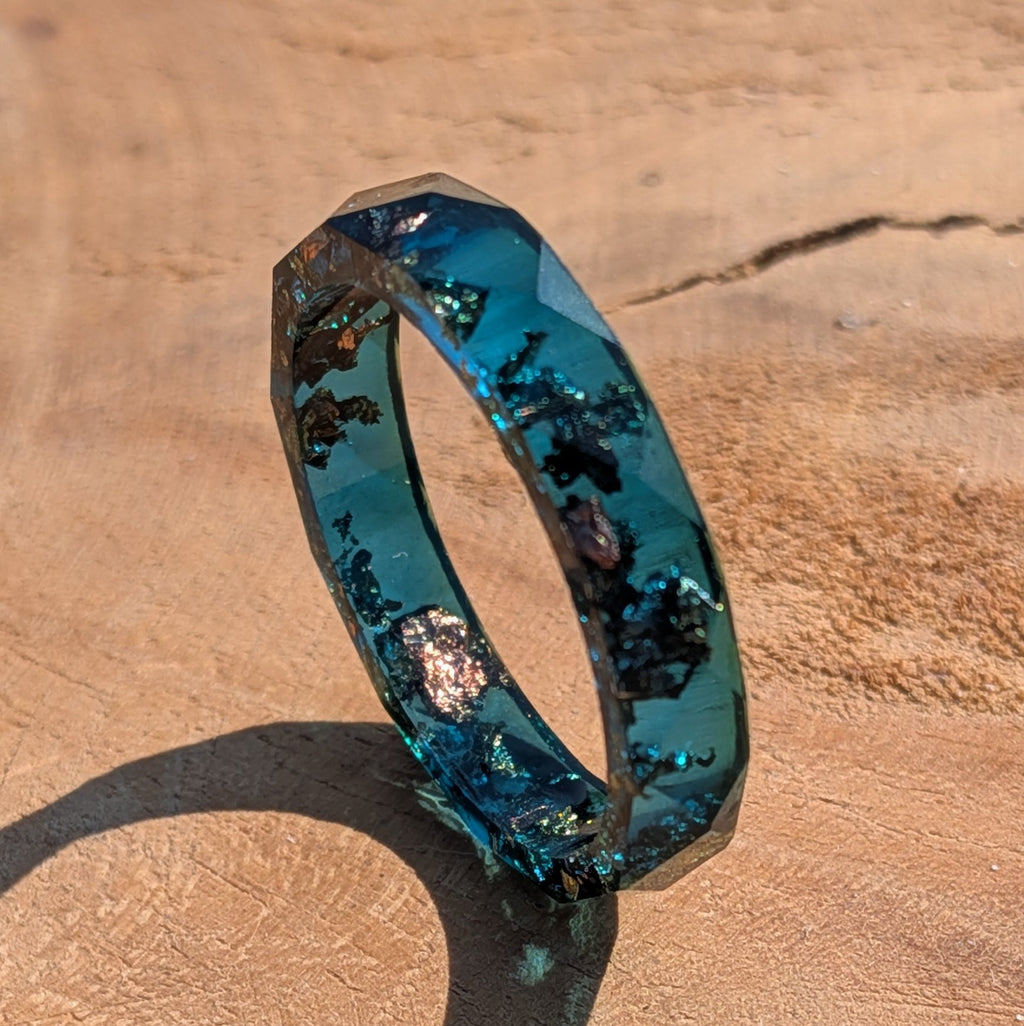 Blue ring with embedded materials on a beige surface