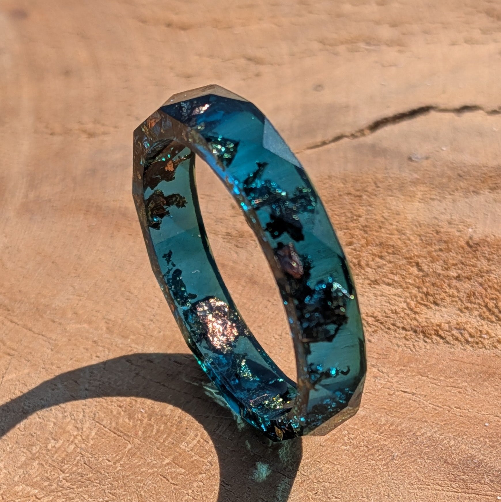 Blue ring with embedded materials on a beige surface