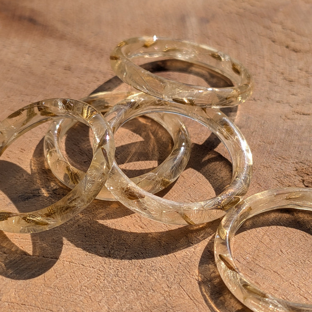 Gold bangles on a wooden surface