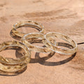 Three gold rings on a wooden surface