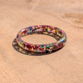 Colorful floral thin ring on a beige surface