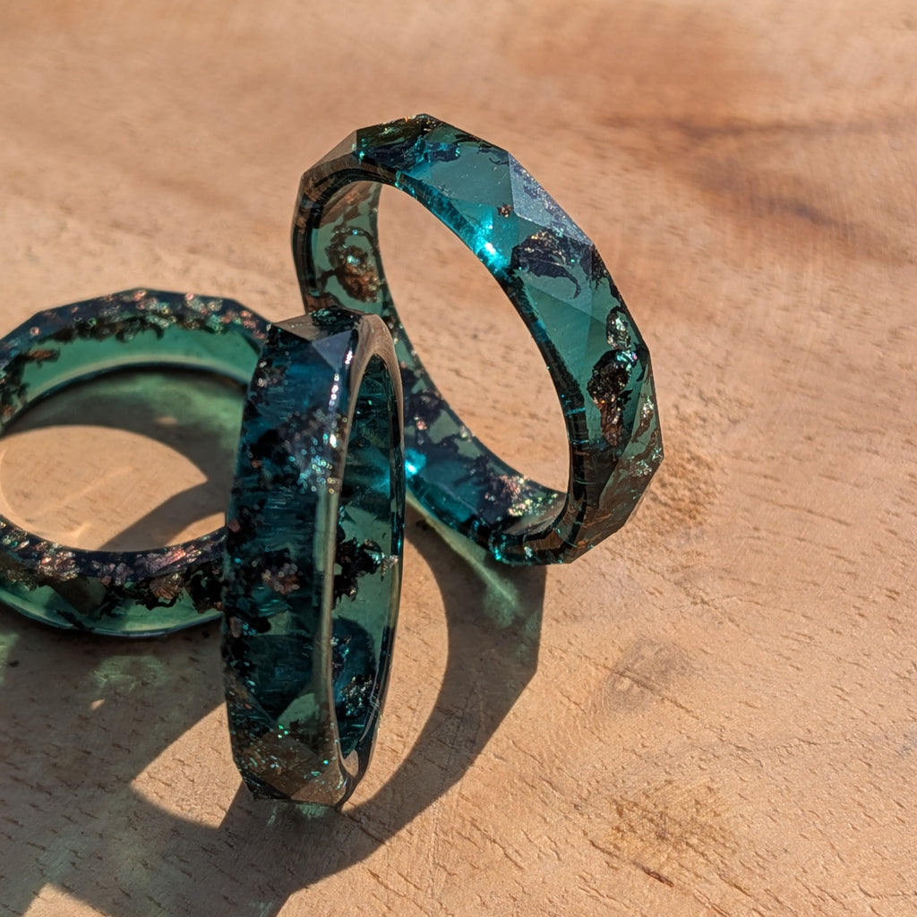 Blue green resin ring on a wooden surface
