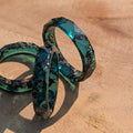 Blue green resin ring on a wooden surface